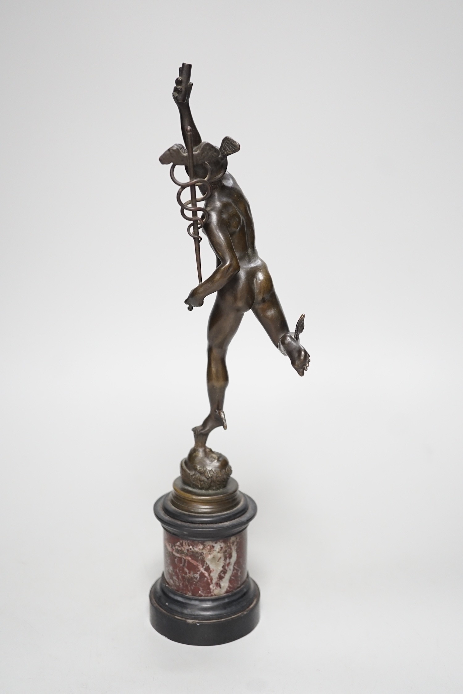 A bronze figure of Mercury on a graduated marble plinth. 33cm tall